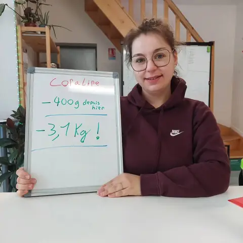 Souriante, une membre brandit l’ardoise où son bilan est écrit